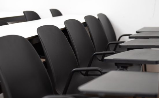 Aula vacía con pupitres individuales lista para clases presenciales.