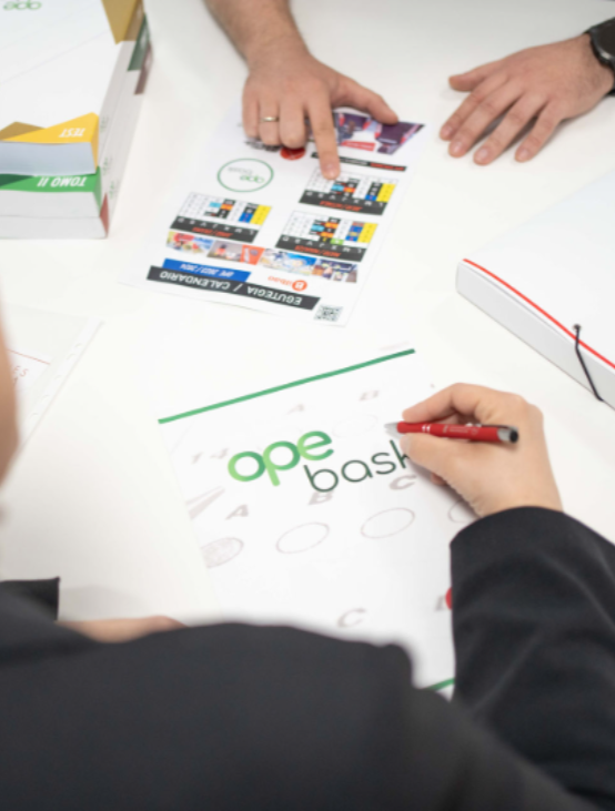 Alumno preparando las oposiciones de Correos en Donostia con material de estudio y apoyo en mesa de trabajo.
